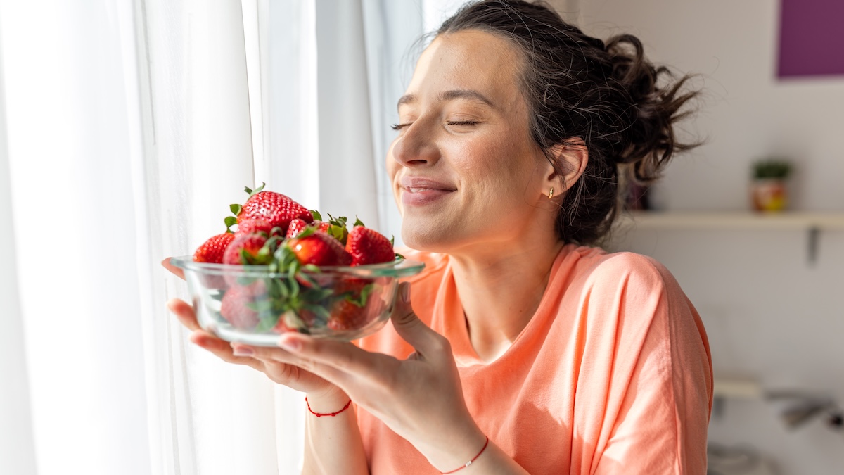 A woman smells strawberries