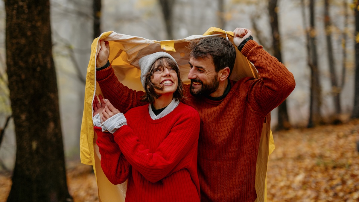 Couple in the fall forest in the rain