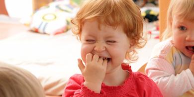 Small child puts his fingers in his mouth
